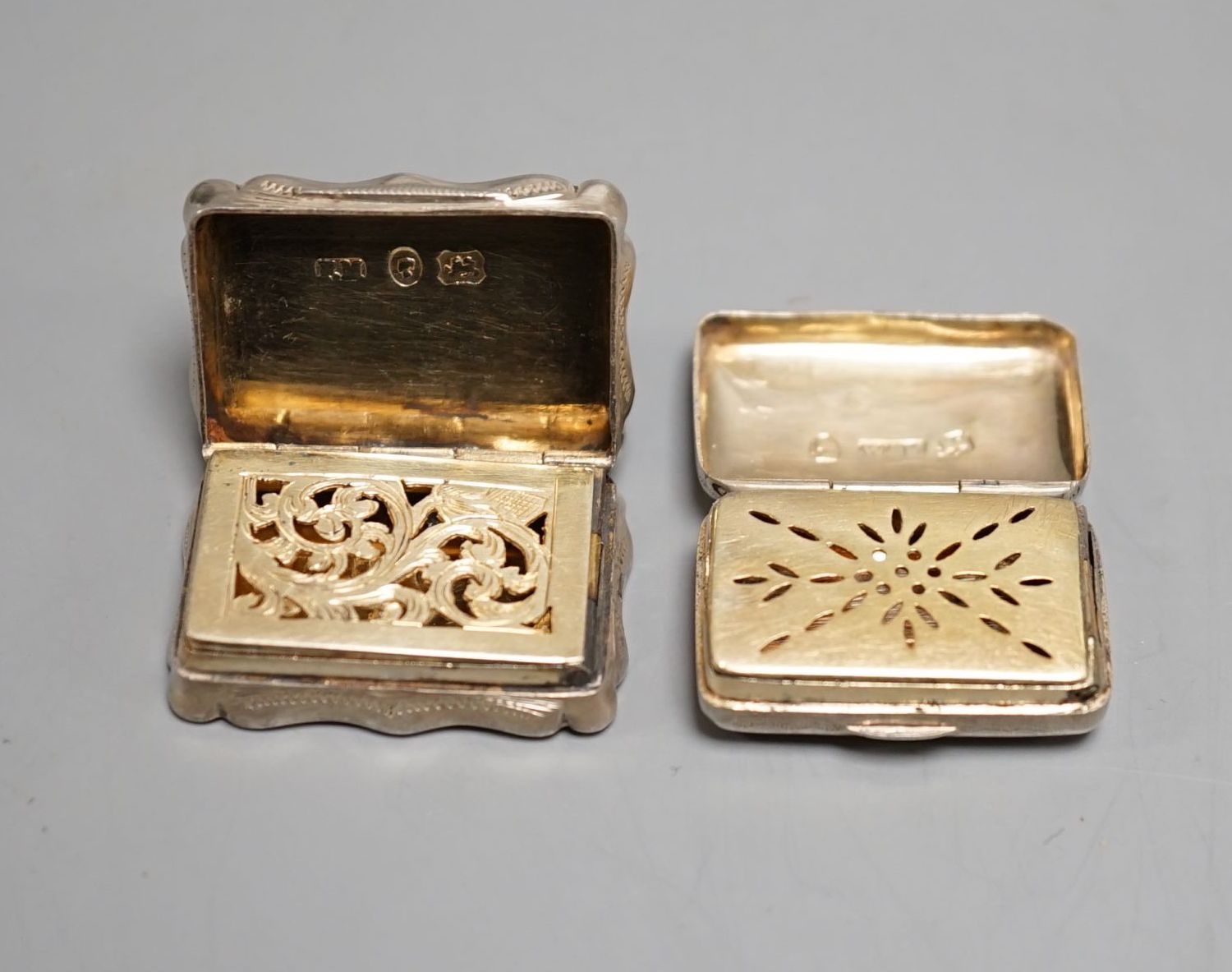 A George III engraved silver rectangular vinaigrette, by Wardell & Kempson, Birmingham, 1811, 27mm and a later silver vinaigrette by Frederick Marsen, Birmingham, 1868, 30mm.